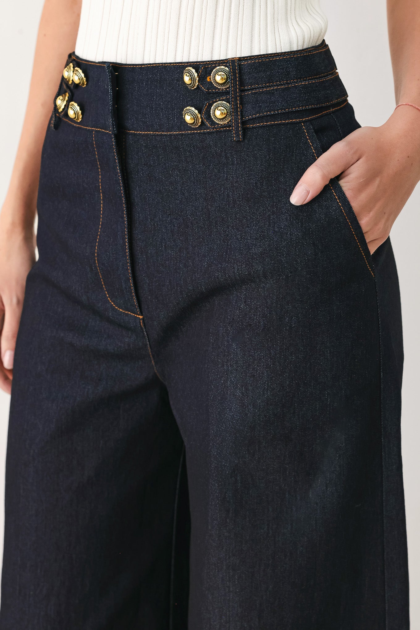 Woman wearing dark denim navy blue wide-leg pants with gold buttons | FREEMARKET