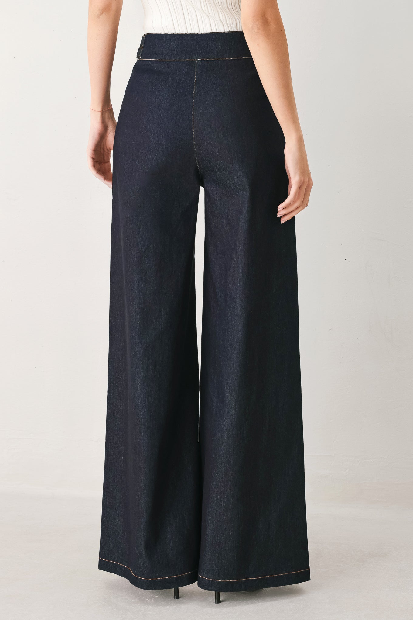 Woman wearing dark denim navy blue wide-leg pants with gold buttons | FREEMARKET