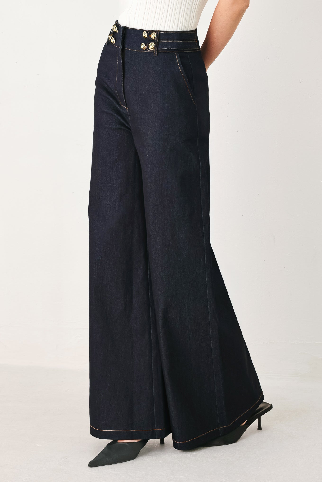 Woman wearing dark denim navy blue wide-leg pants with gold buttons | FREEMARKET