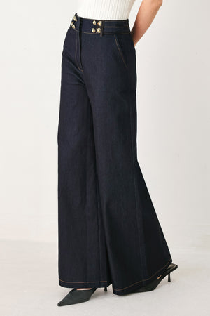 Woman wearing dark denim navy blue wide-leg pants with gold buttons | FREEMARKET