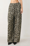 Woman wearing a brown and black leopard print pants with elastic waist | FREEMARKET

