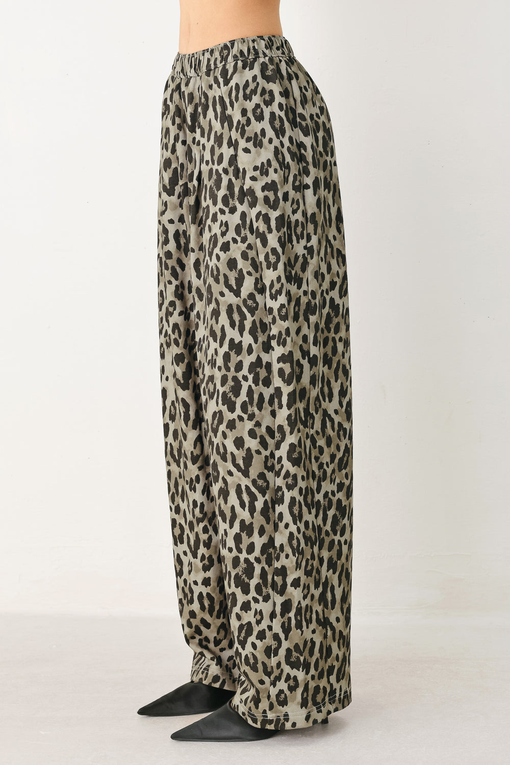 Woman wearing a brown and black leopard print pants with elastic waist | FREEMARKET
