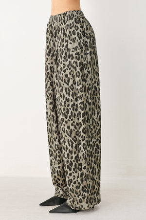 Woman wearing a brown and black leopard print pants with elastic waist | FREEMARKET
