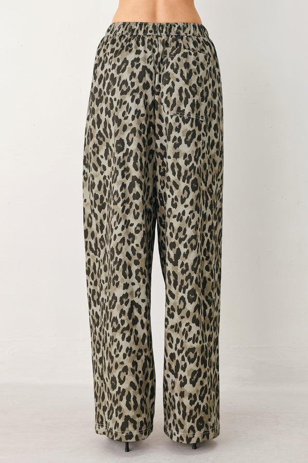 Woman wearing a brown and black leopard print pants with elastic waist | FREEMARKET