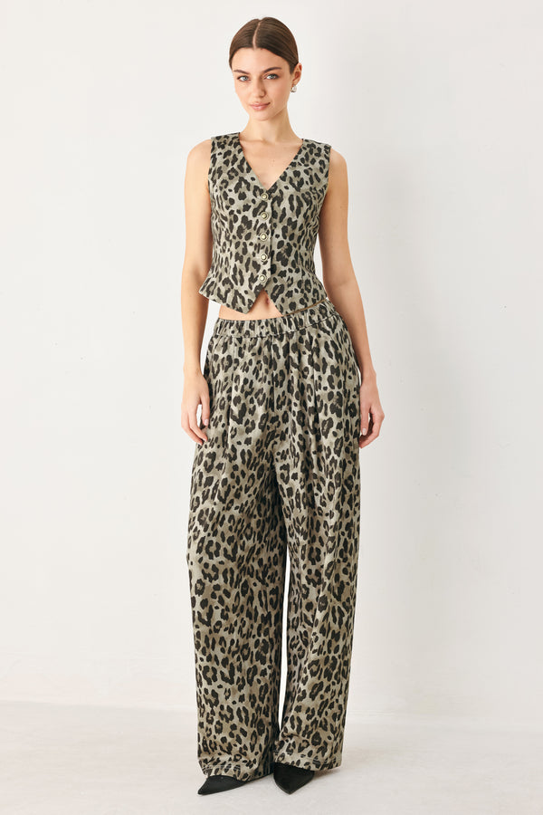 Woman wearing a brown and black leopard print pants with elastic waist | FREEMARKET