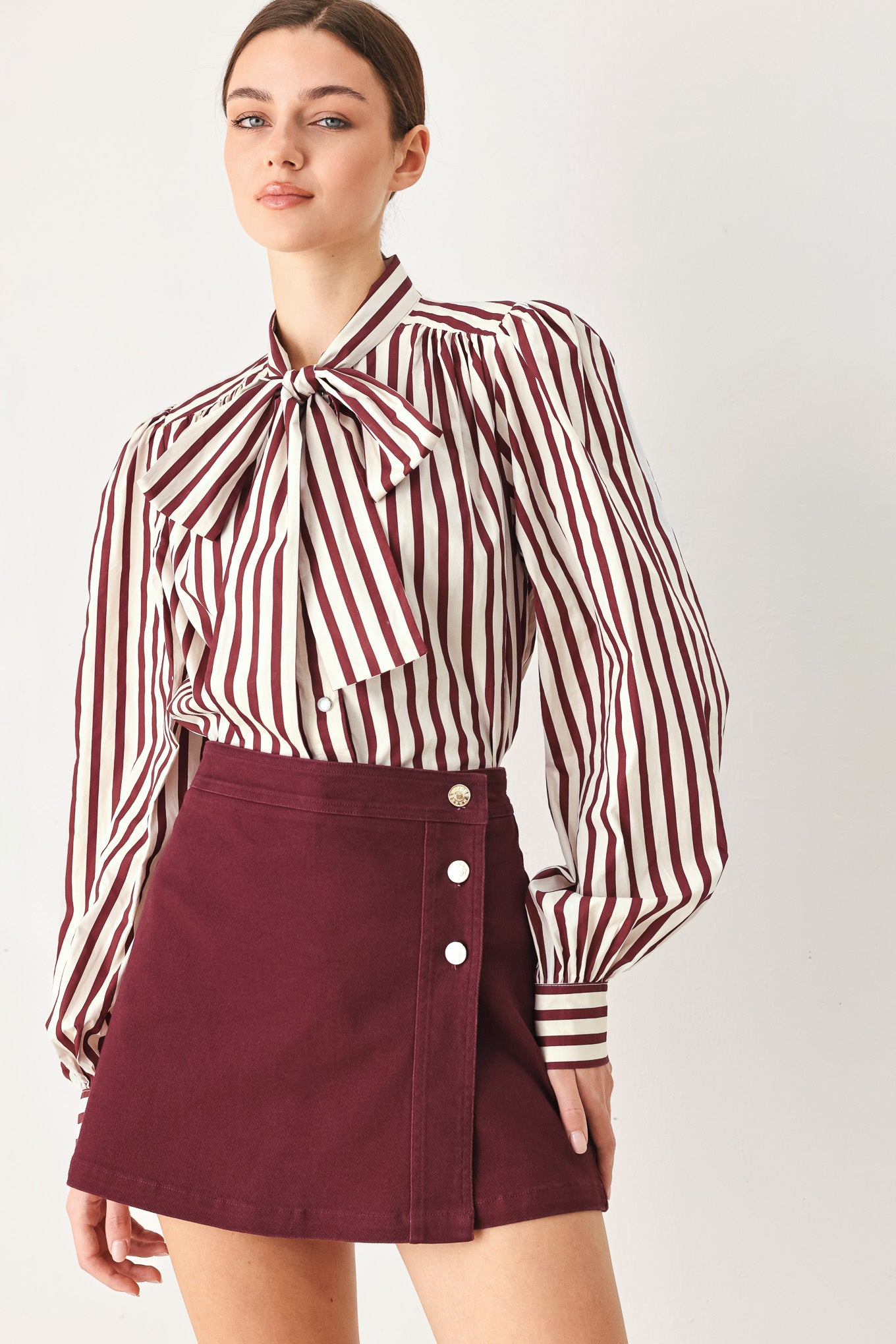 Woman wearing a dark burgundy mini skort with front buttons | FREEMARKET