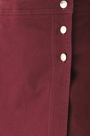 Woman wearing a dark burgundy mini skort with front buttons | FREEMARKET