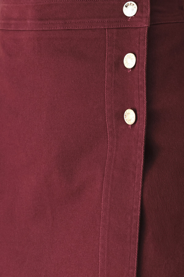 Woman wearing a dark burgundy mini skort with front buttons | FREEMARKET