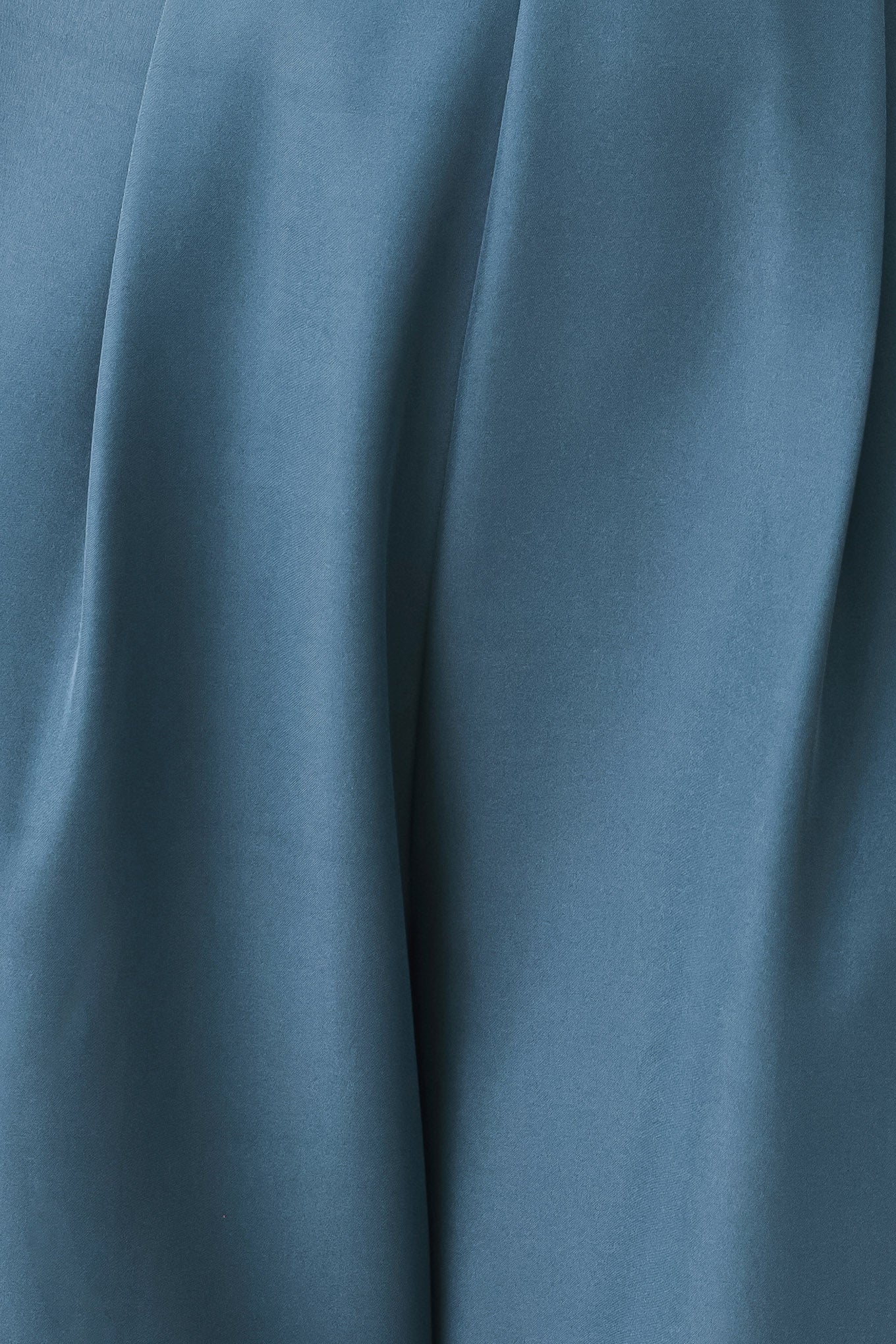 A woman modeling a teal blue halter-neck wide-leg jumpsuit with a deep V-neckline and side pockets | FREEMARKET