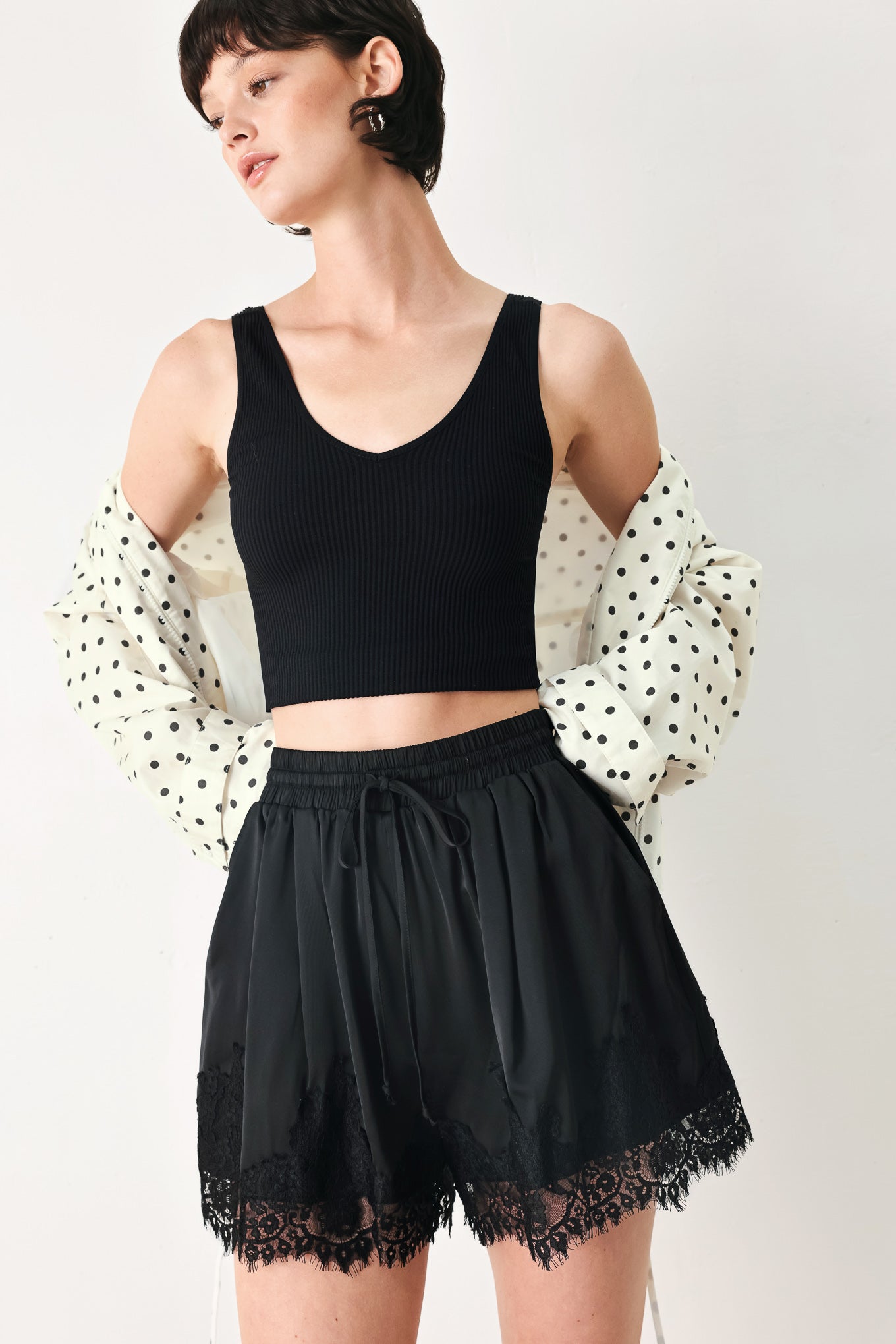 Woman wearing black shorts with lace trim and elastic waistband | FREEMARKET
