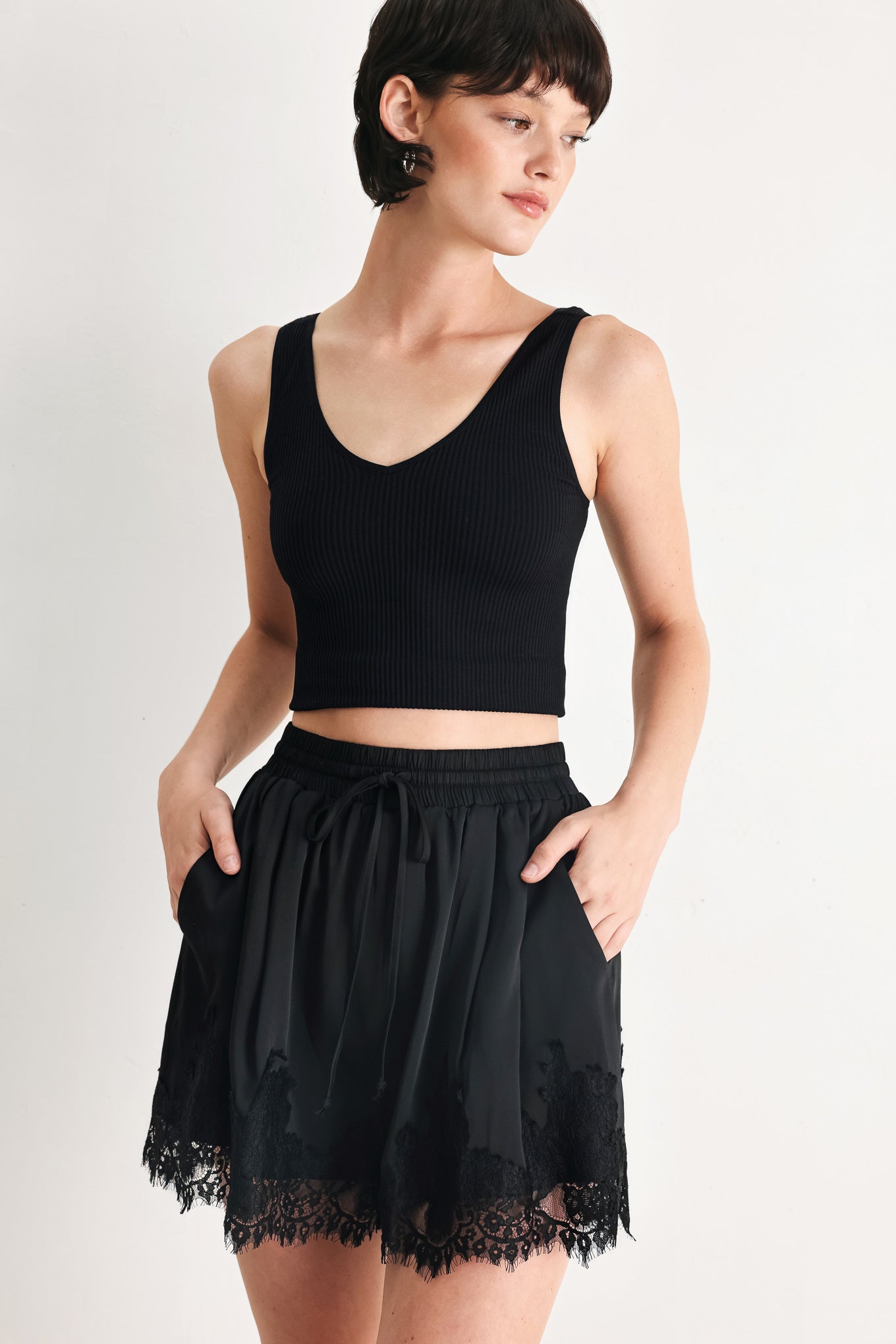 Woman wearing black shorts with lace trim and elastic waistband | FREEMARKET