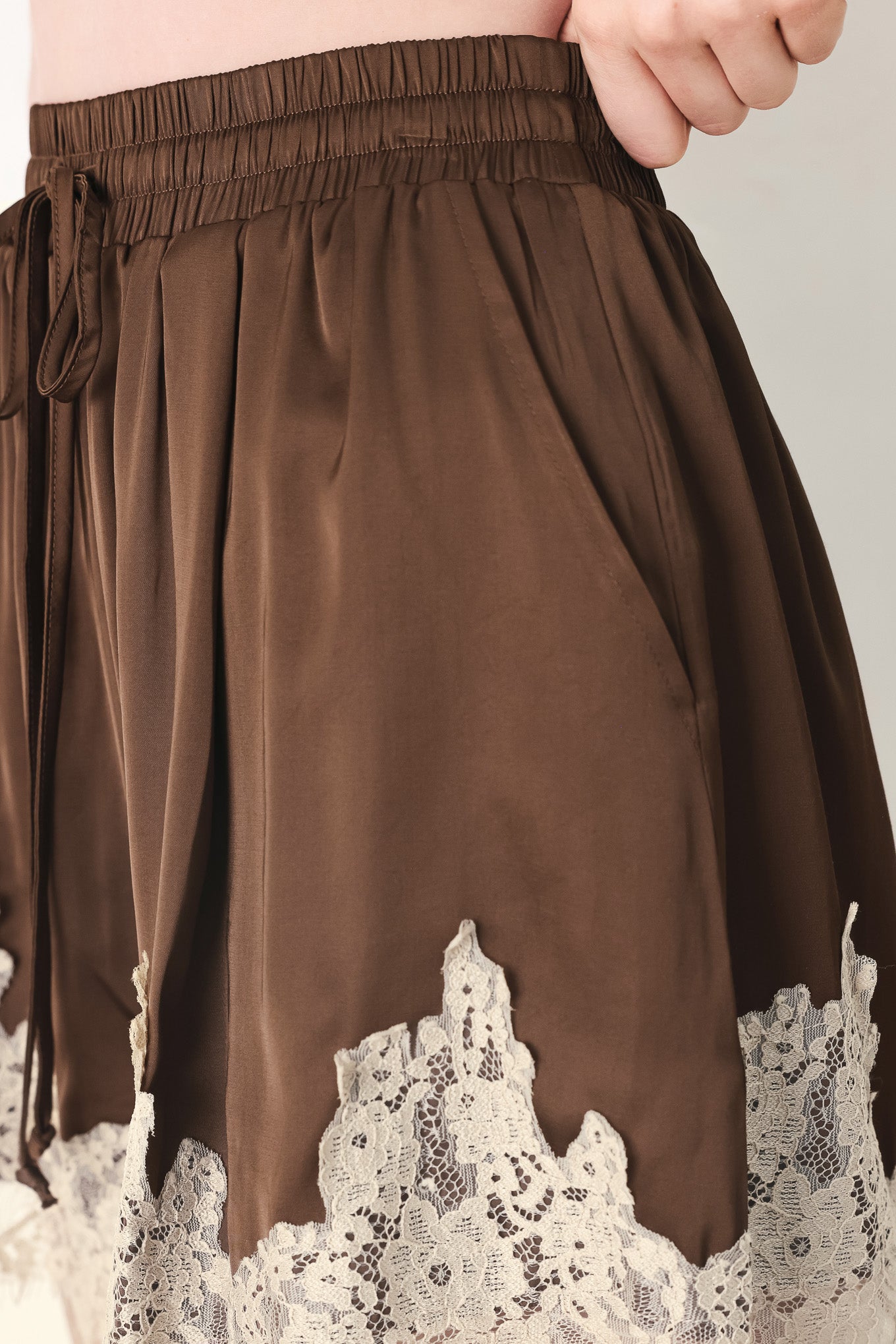 Woman wearing brown shorts with lace trim and elastic waistband | FREEMARKET