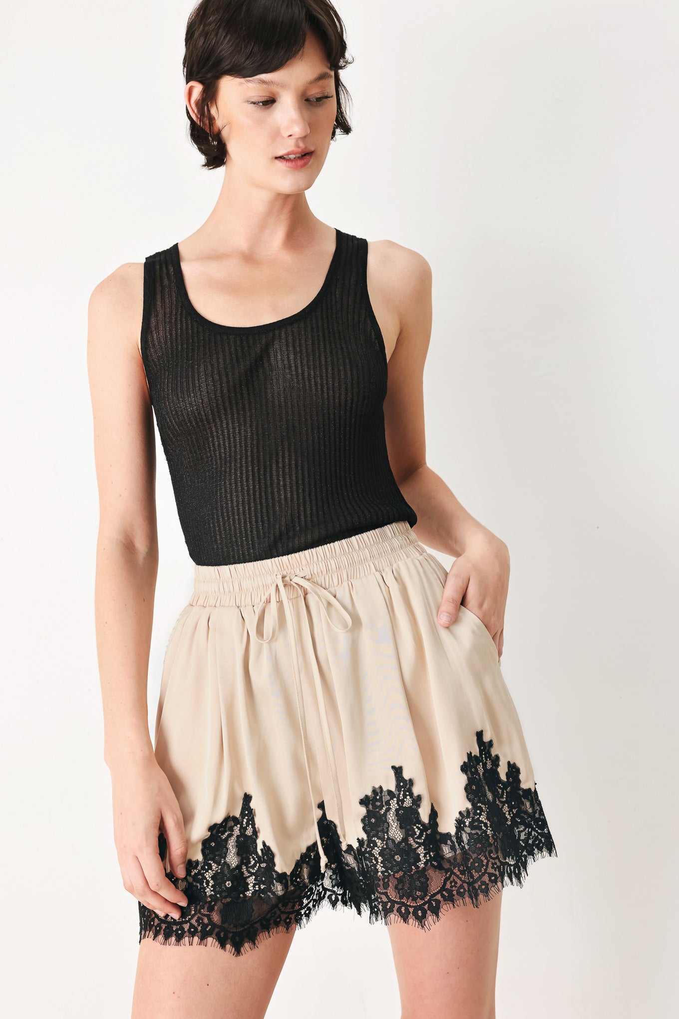 Woman wearing beige shorts with lace trim and elastic waistband | FREEMARKET