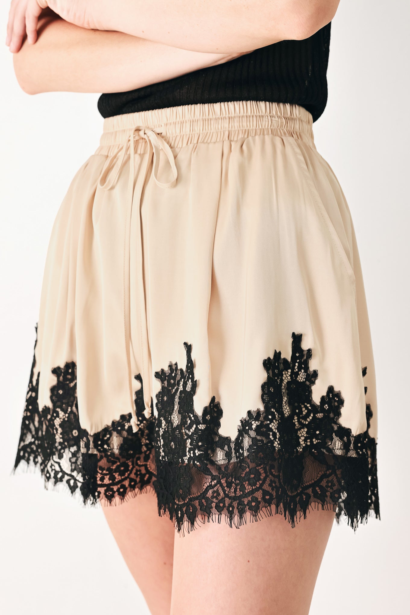Woman wearing beige shorts with lace trim and elastic waistband | FREEMARKET