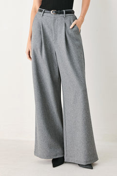 Woman wearing gray wide-leg pant with front closure, single pleat, pockets, and black belt | FREEMARKET