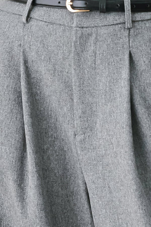 Woman wearing gray wide-leg pant with front closure, single pleat, pockets, and black belt | FREEMARKET