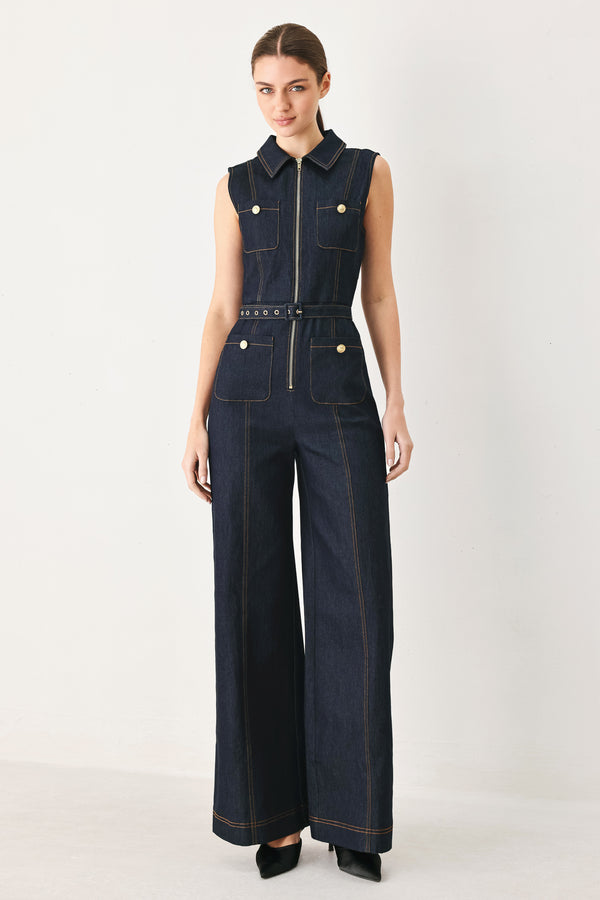 Woman wearing a dark blue denim sleeveless, wide-leg jumpsuit featuring collar, front zipper closure, and pockets | FREEMARKET
