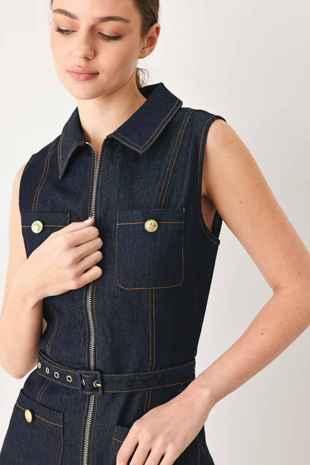 Woman wearing a dark blue denim sleeveless, wide-leg jumpsuit featuring collar, front zipper closure, and pockets | FREEMARKET
