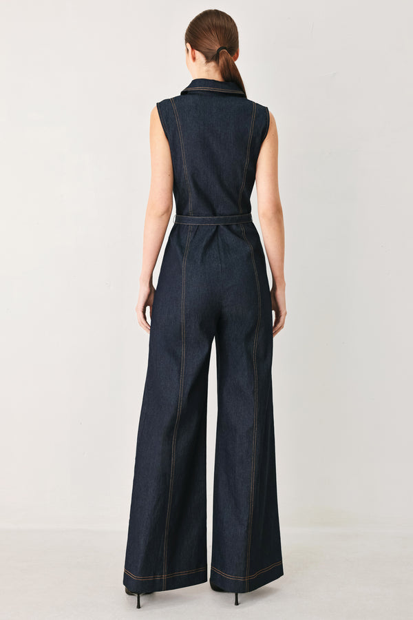 Woman wearing a dark blue denim sleeveless, wide-leg jumpsuit featuring collar, front zipper closure, and pockets | FREEMARKET