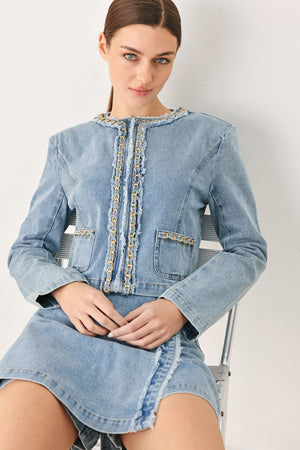 Woman wearing a light denim skort and matching jacket with fray edge, chain waist detail and back zipper closure | FREEMARKET