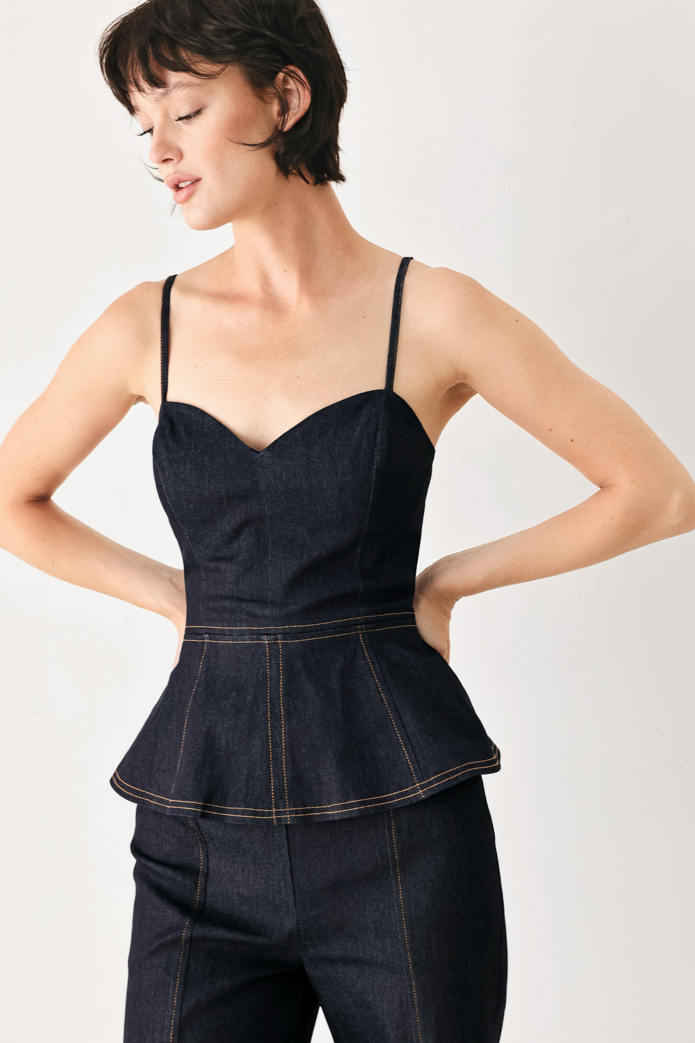 Woman wearing a dark denim jumpsuit with a peplum top and wide-leg pants style | FREEMARKET