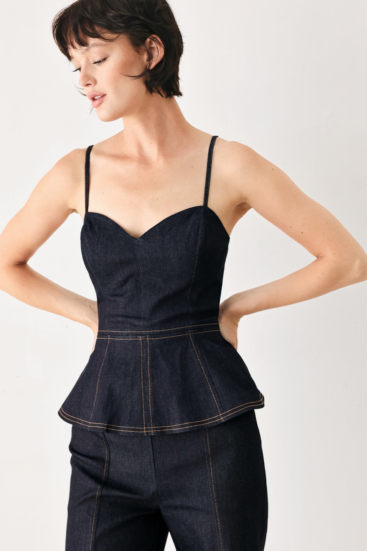 Woman wearing a dark denim jumpsuit with a peplum top and wide-leg pants style | FREEMARKET