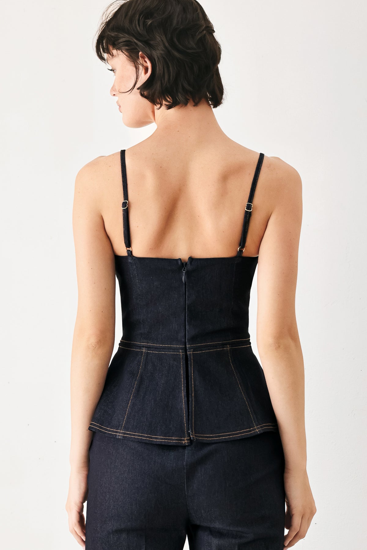 Woman wearing a dark denim jumpsuit with a peplum top and wide-leg pants style | FREEMARKET