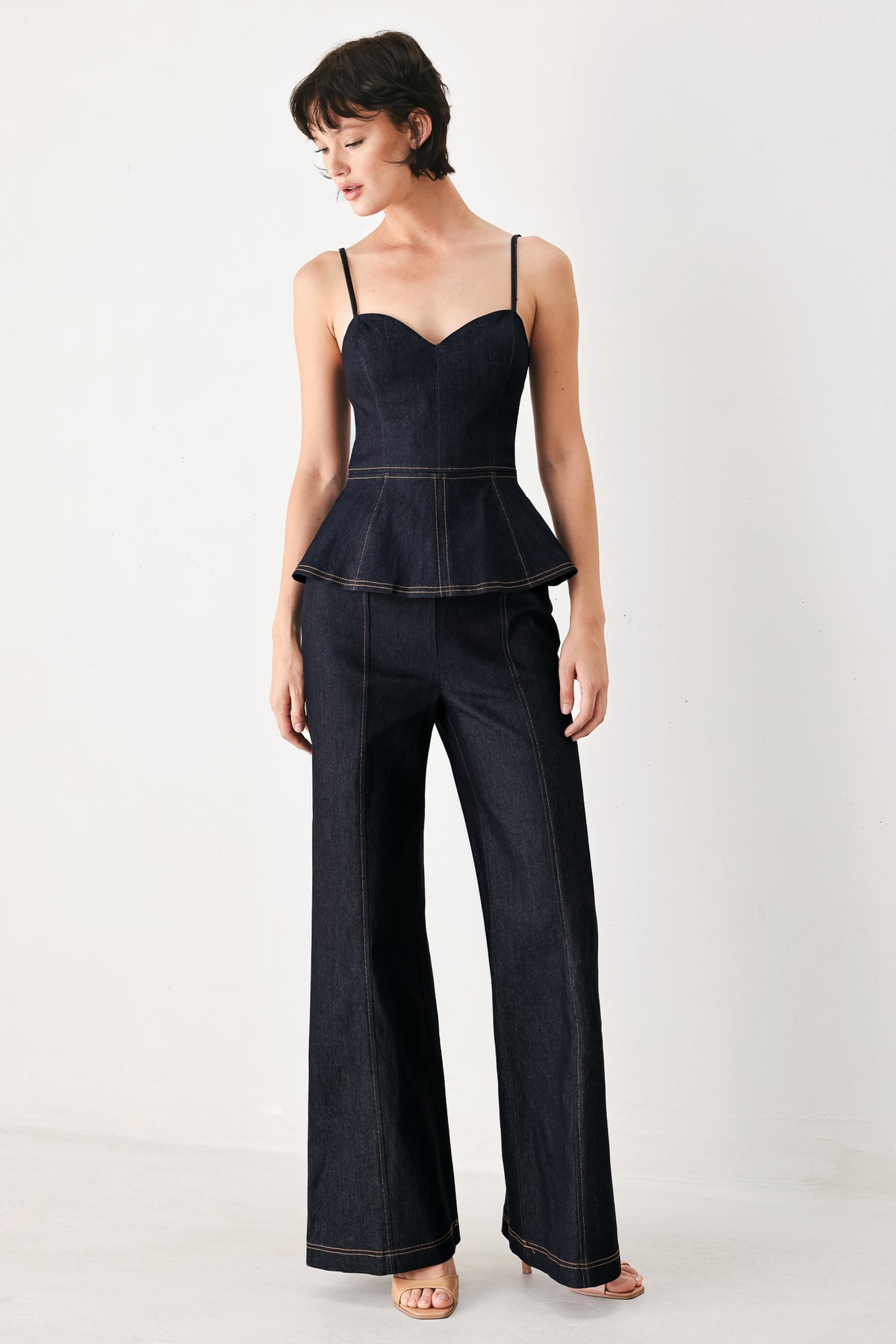 Woman wearing a dark denim jumpsuit with a peplum top and wide-leg pants style | FREEMARKET