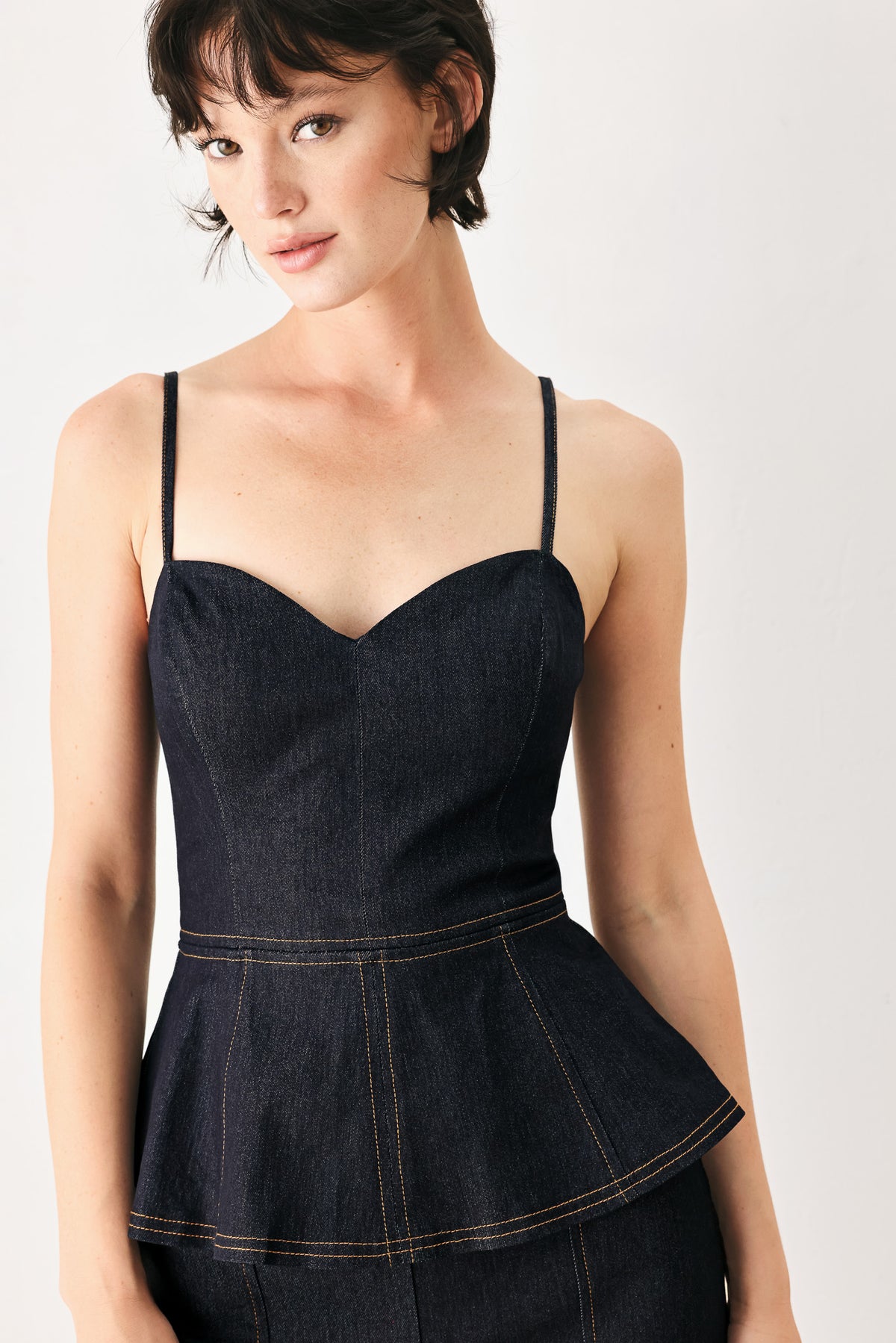 Woman wearing a dark denim jumpsuit with a peplum top and wide-leg pants style | FREEMARKET