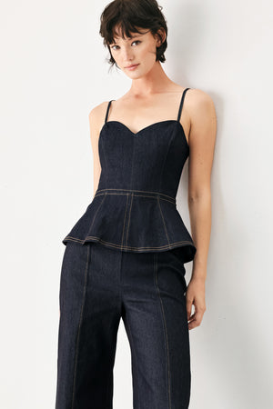 Woman wearing a dark denim jumpsuit with a peplum top and wide-leg pants style | FREEMARKET
