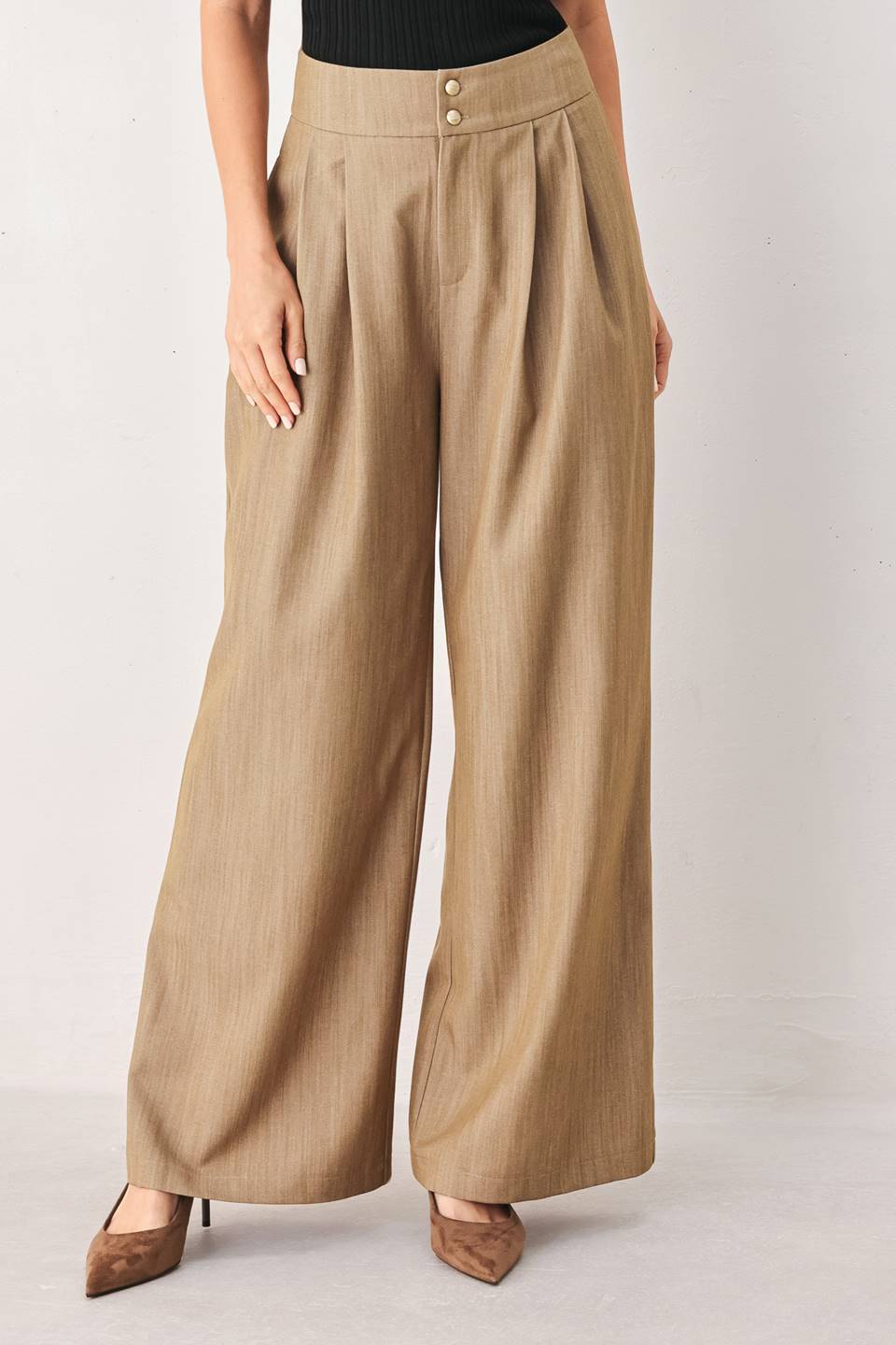 A model wearing high-waisted, wide-leg trousers in a light tan color with buttons | FREEMARKET