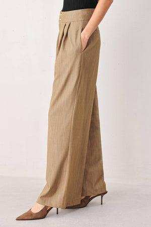 A model wearing high-waisted, wide-leg trousers in a light tan color with buttons | FREEMARKET