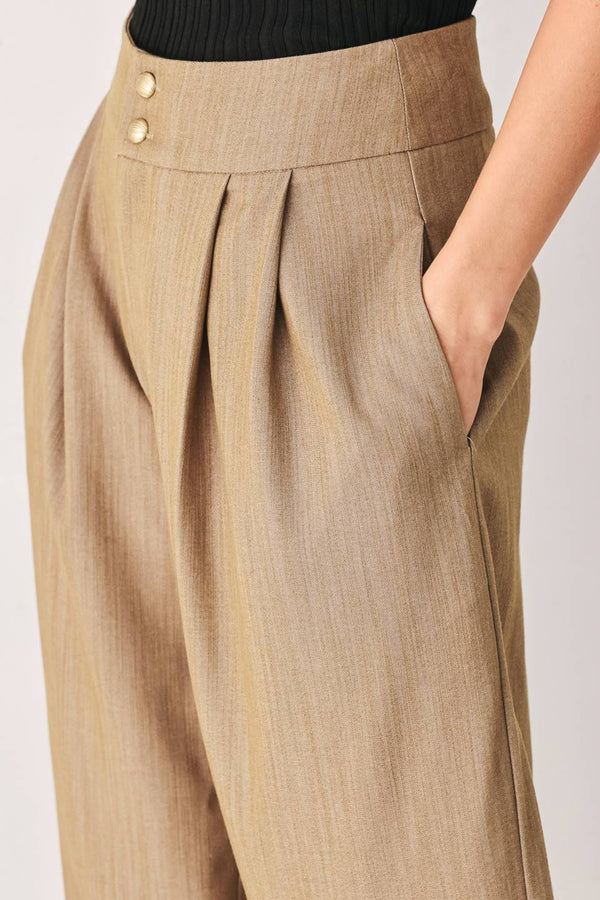 A model wearing high-waisted, wide-leg trousers in a light tan color with buttons | FREEMARKET