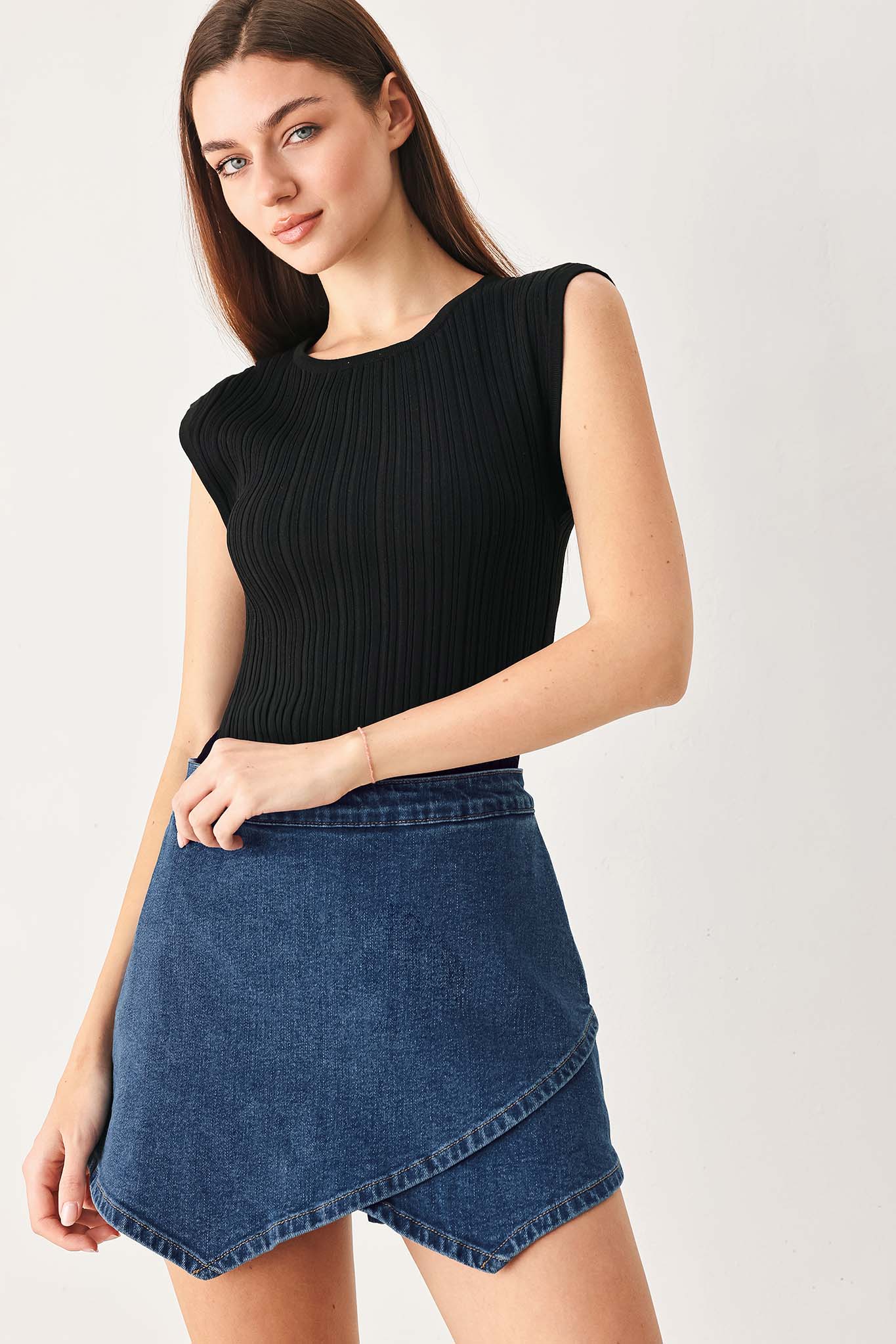 Woman wearing a blue denim mini skort with an asymmetrical wrap-style hem | FREEMARKET
