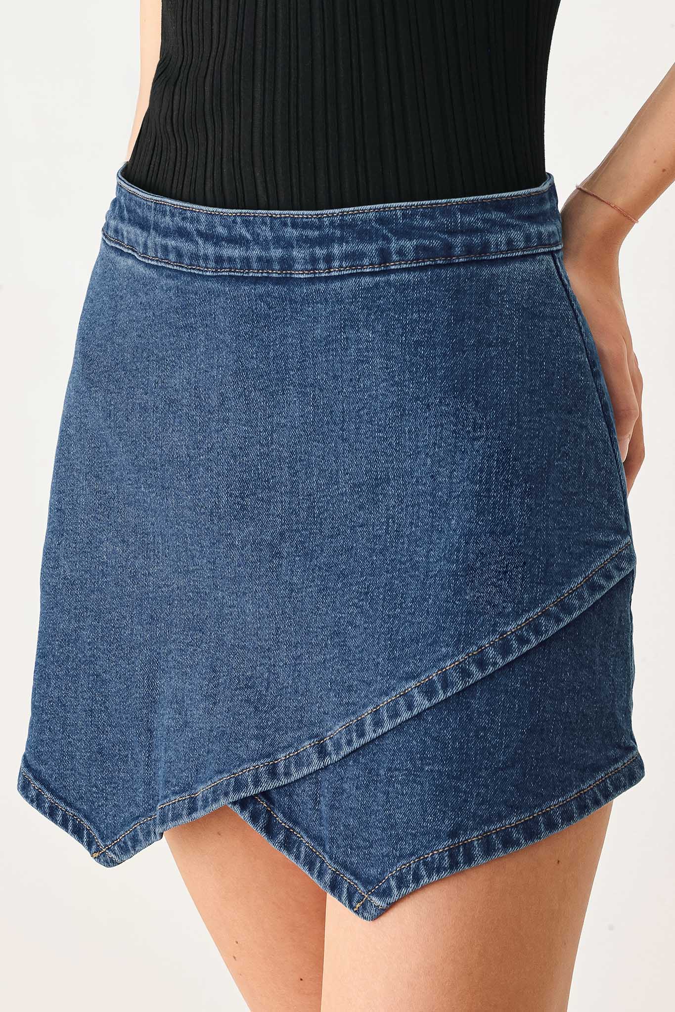 Woman wearing a blue denim mini skort with an asymmetrical wrap-style hem | FREEMARKET