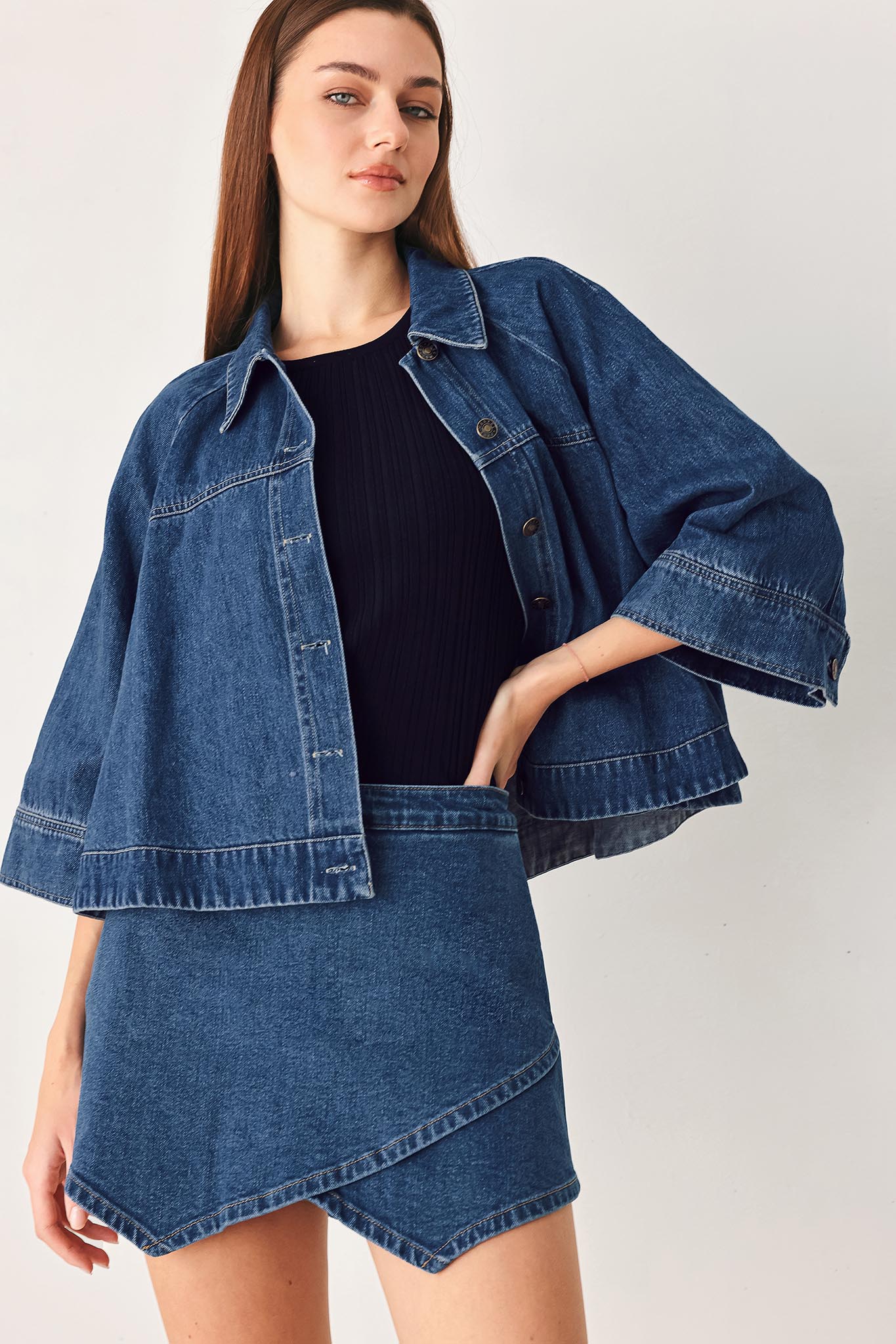 Woman wearing a blue denim mini skort with an asymmetrical wrap-style hem | FREEMARKET