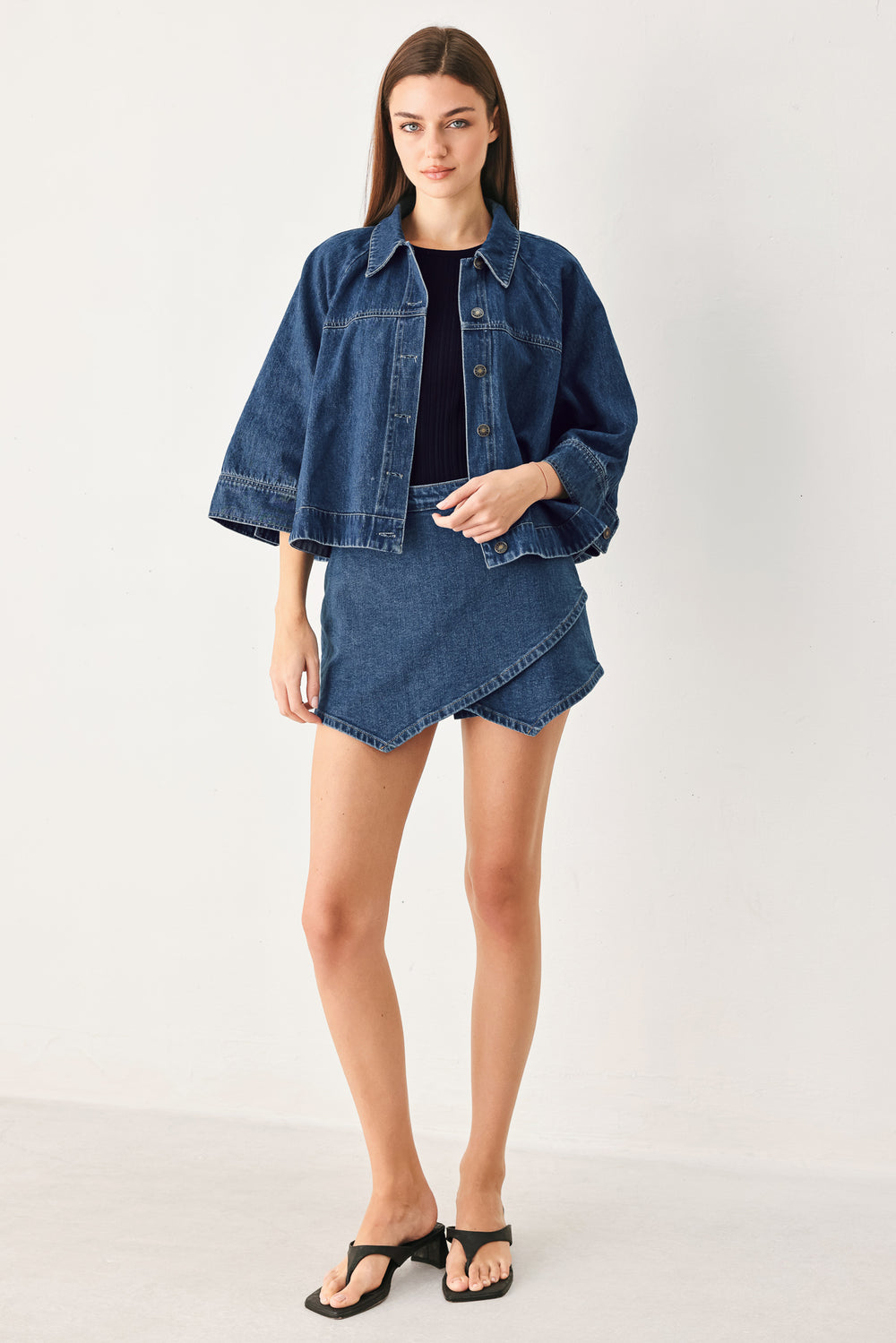 Woman wearing a blue denim mini skort with an asymmetrical wrap-style hem | FREEMARKET