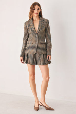 A person wearing a brown and beige plaid pleated houndstooth mini skort | FREEMARKET