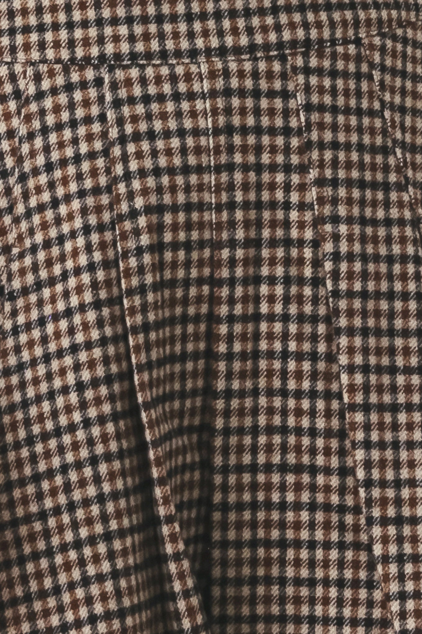 Close-up of a brown, beige, and black checkered fabric texture.