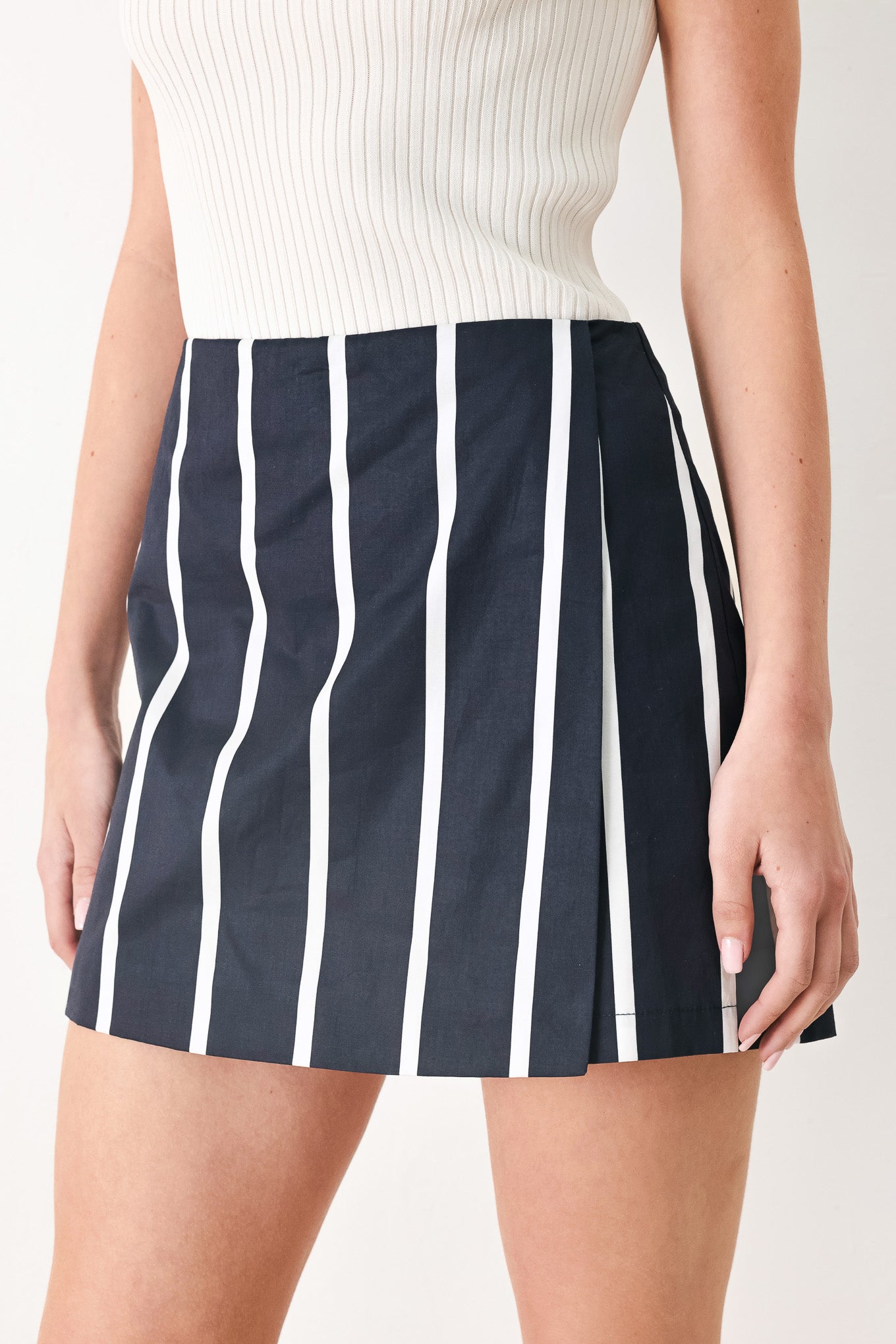 Woman wearing a navy blue and white striped skort with back zipper closure | FREEMARKET
