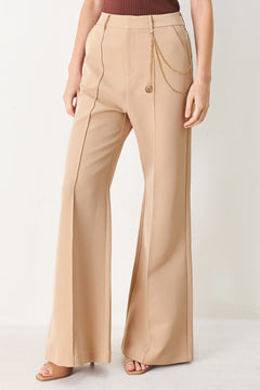 Woman wearing camel beige wide-leg pants with a chain detail on the side | FREEMARKET