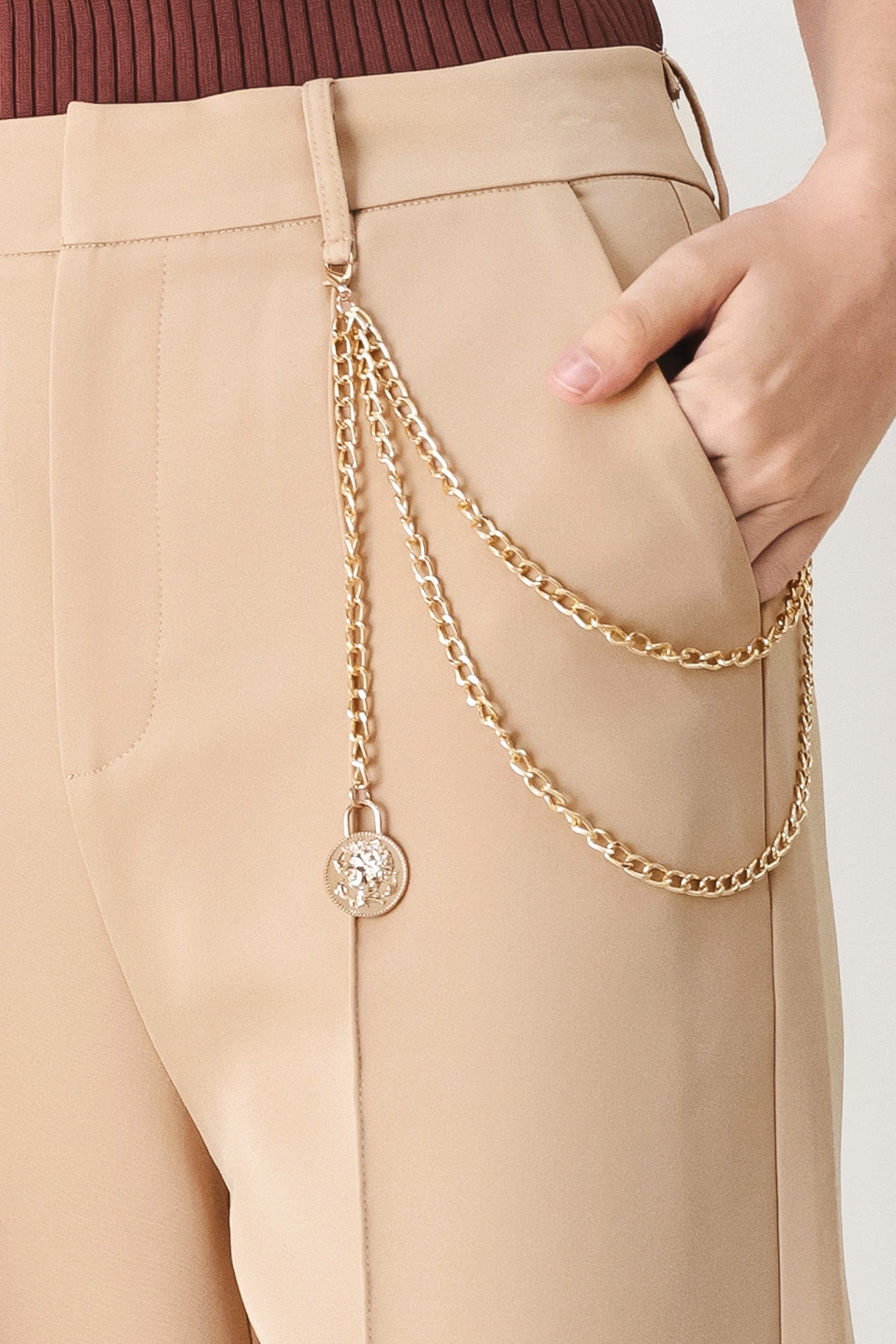 Woman wearing camel beige wide-leg pants with a chain detail on the side | FREEMARKET