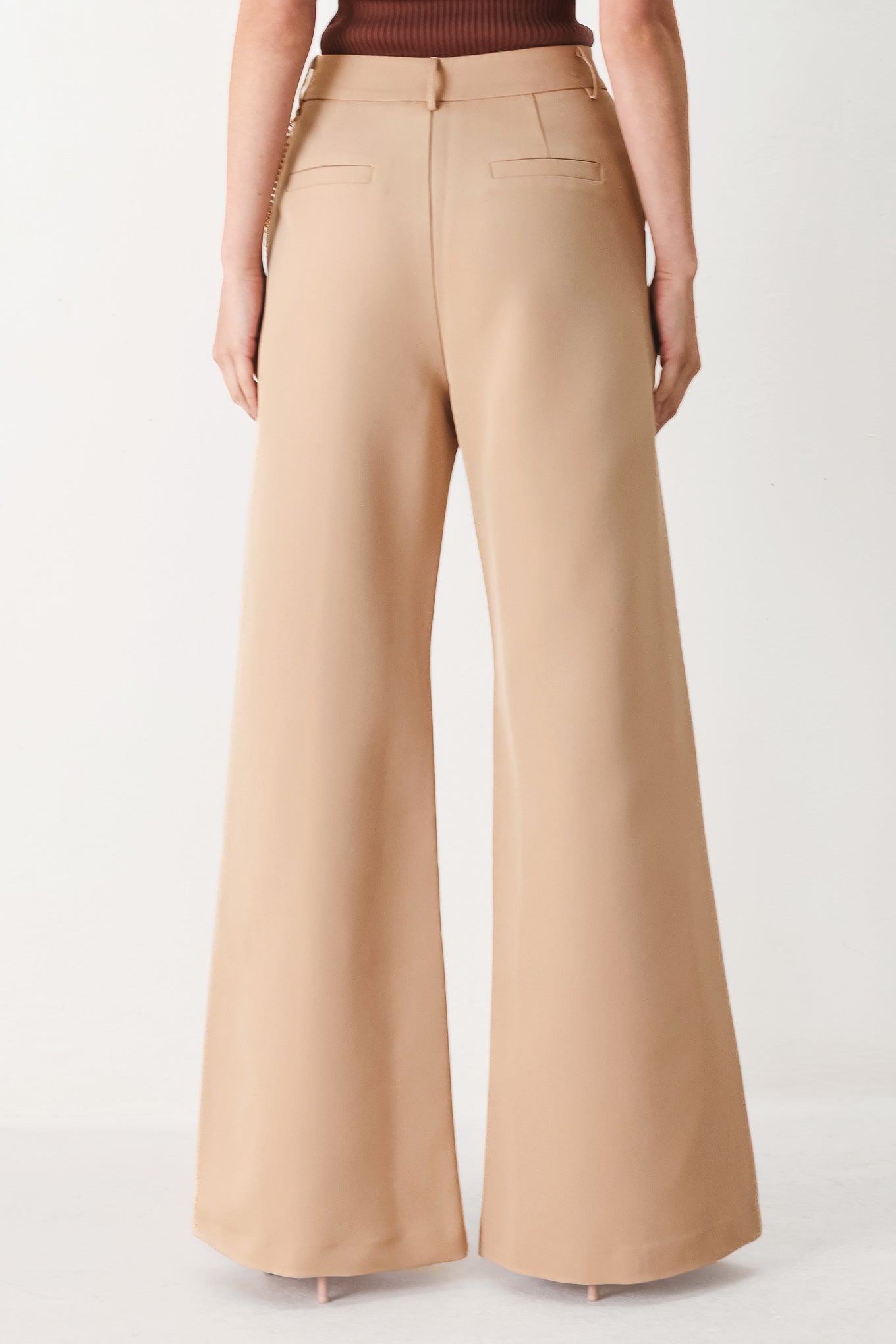 Woman wearing camel beige wide-leg pants with a chain detail on the side | FREEMARKET