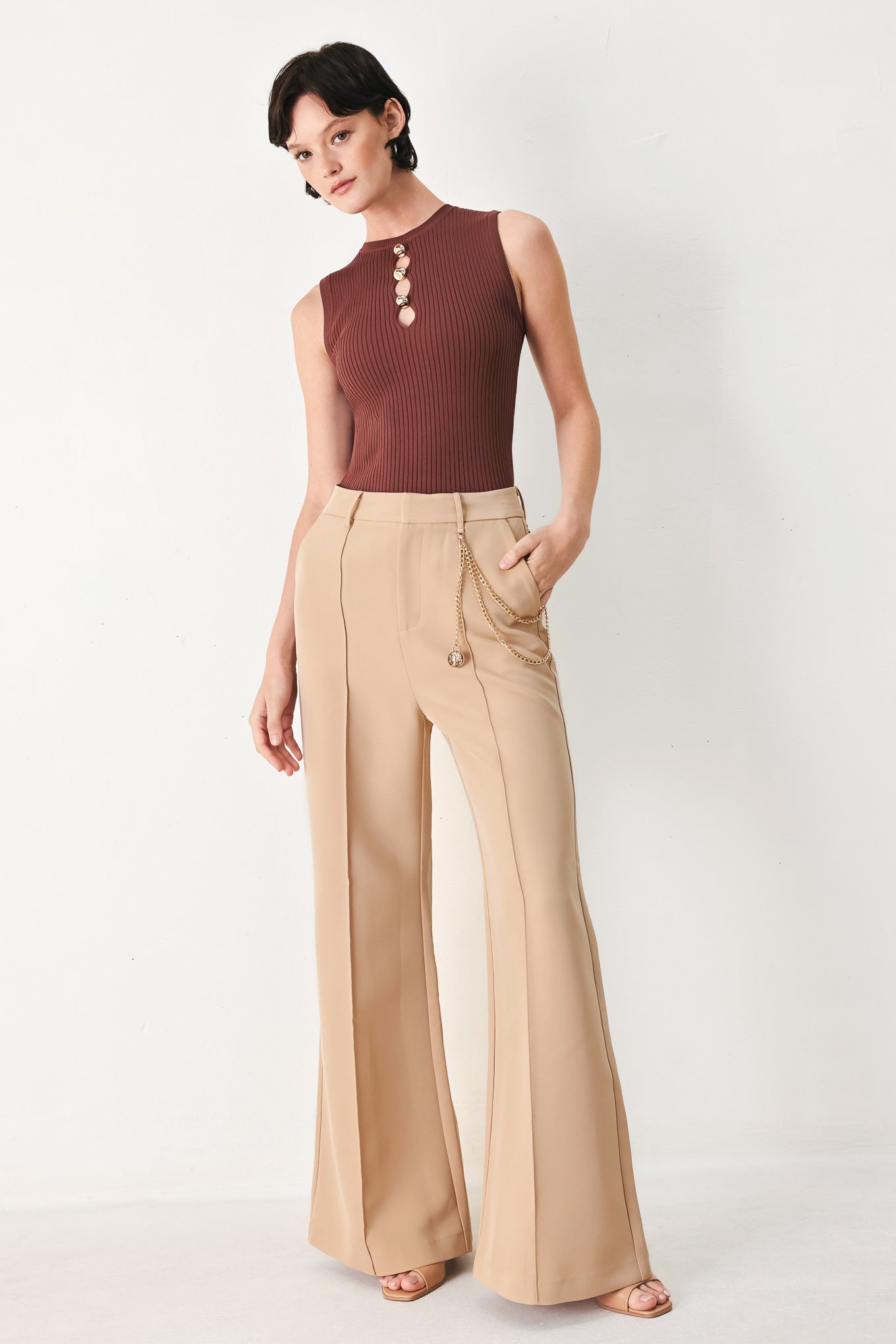 Woman wearing camel beige wide-leg pants with a chain detail on the side | FREEMARKET