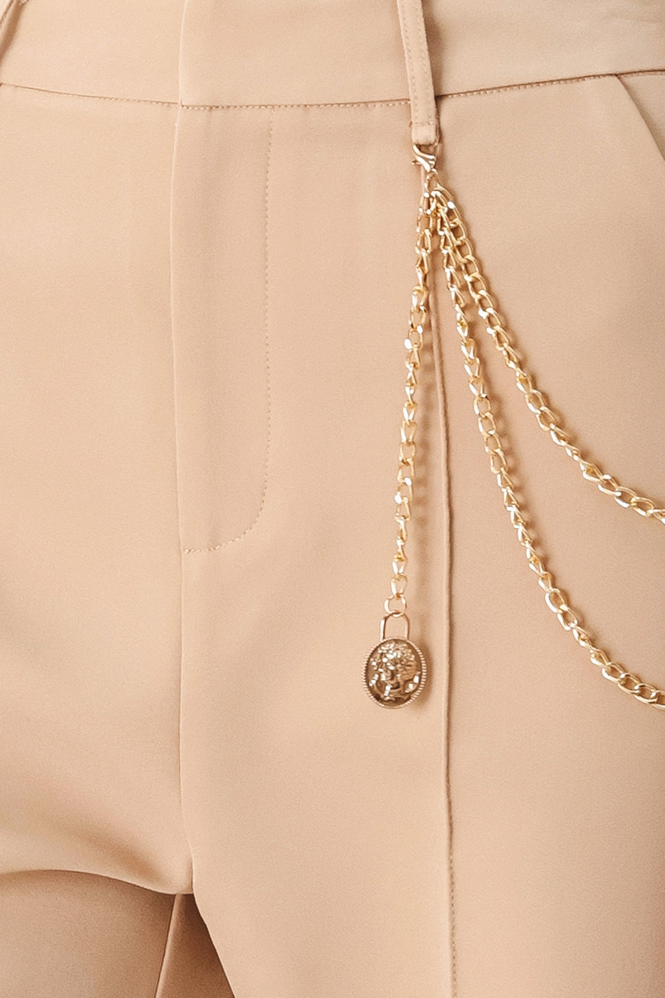 Woman wearing camel beige wide-leg pants with a chain detail on the side | FREEMARKET