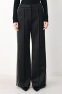 Model wearing black wide-leg trousers with white side stripes | FREEMARKET