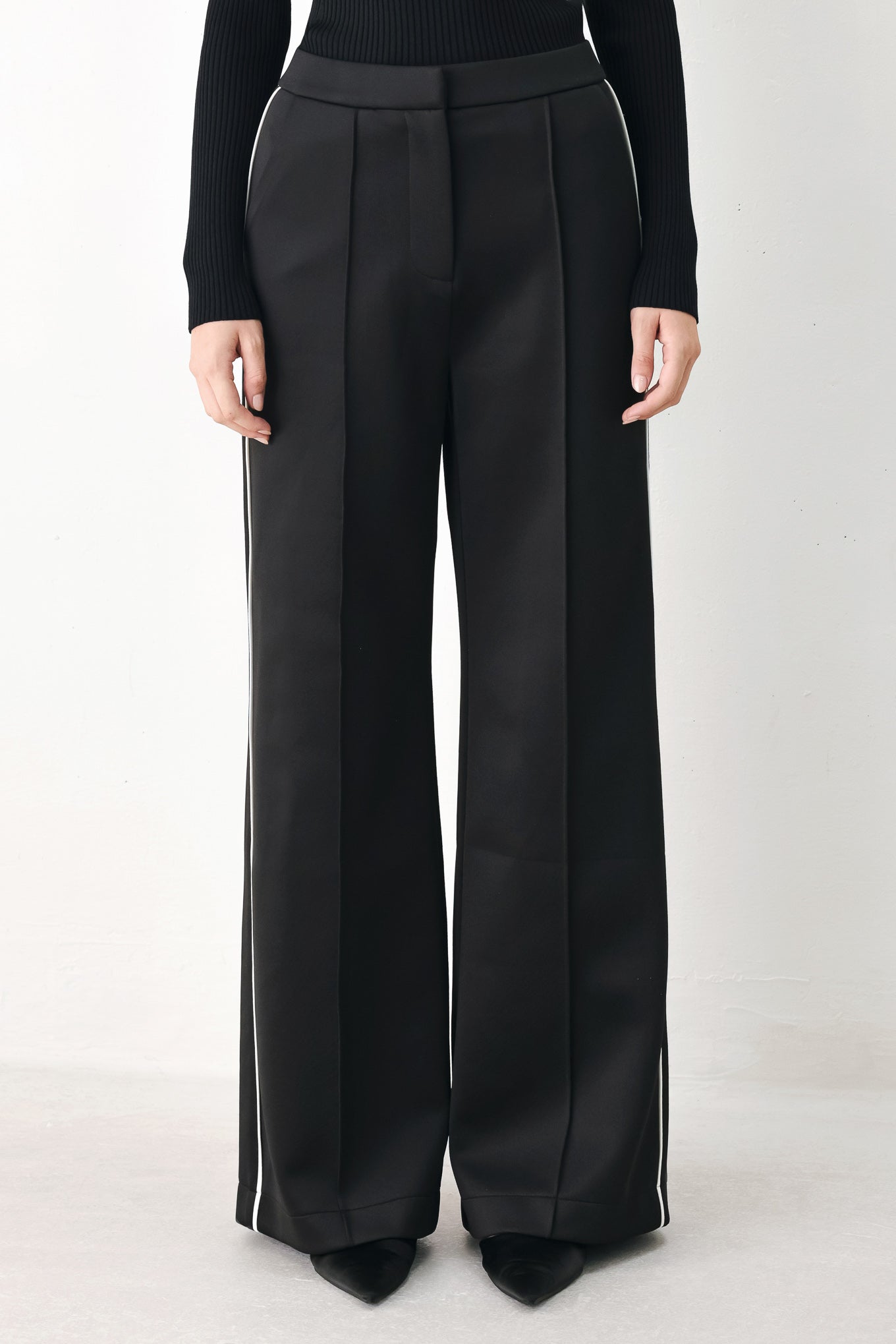 Model wearing black wide-leg trousers with white side stripes | FREEMARKET