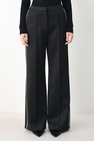 Model wearing black wide-leg trousers with white side stripes | FREEMARKET