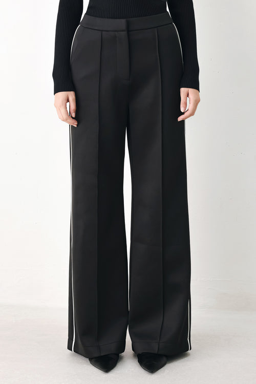 Model wearing black wide-leg trousers with white side stripes | FREEMARKET