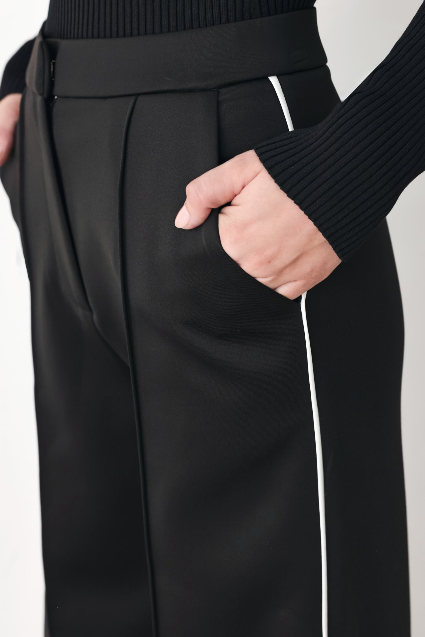 Model wearing black wide-leg trousers with white side stripes | FREEMARKET